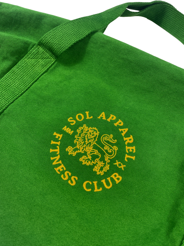 close up of sol apparel fitness club green gym duffel bag with golden lion logo embroidered on the side