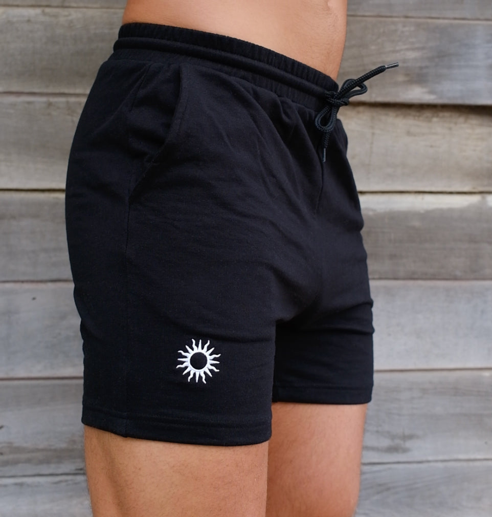 close up of man wearing black mens training shorts with white embroidered sun