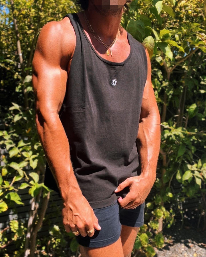 ripped man with gold chains and rings wearing black natural cotton tank top with white sun logo